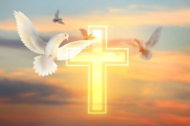 Parlayan haç ve bulutlu gökyüzünde güvercinler