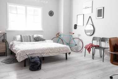 Modern bisiklet ve sandalyeli aydınlık yatak odasının içi