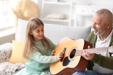 Küçük kız ve gitarlı dedesi.