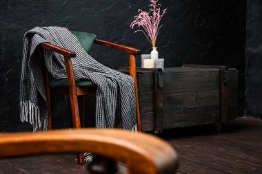 Koltuklu, ekoseli ve çekmeceli karanlık odanın içi.