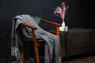 Koltuklu, ekoseli ve çekmeceli karanlık odanın içi.