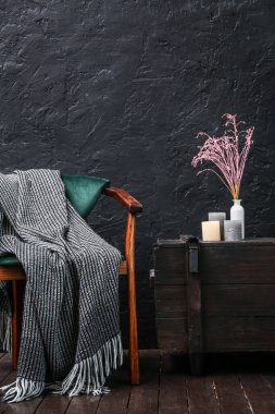 Koltuklu, ekoseli ve çekmeceli karanlık odanın içi.