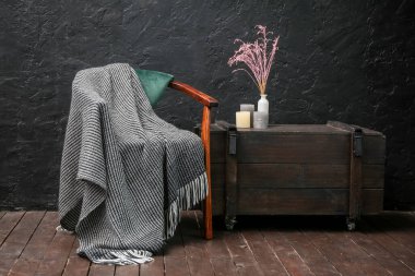 Koltuklu, ekoseli ve çekmeceli karanlık odanın içi.