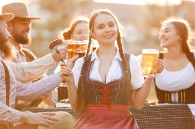 Bira ve aperatifli kadın Ekim Festivali 'ni dışarıda kutluyor.