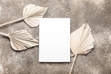 Güzel kurumuş çiçekler ve gri arkaplanda boş bir kağıt.