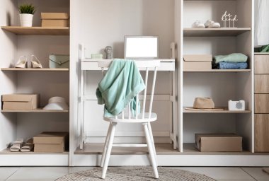 Modern gardıropta dizüstü bilgisayarı olan rahat bir iş yeri.