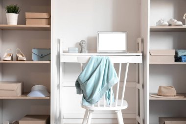 Modern gardıropta dizüstü bilgisayarı olan rahat bir iş yeri.