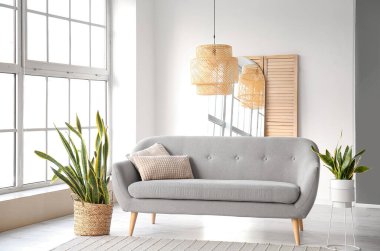 Oturma odasının içi kanepe ve çiçeklerle dolu.