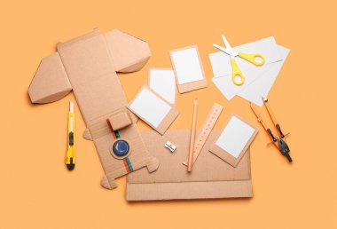 Turuncu arka planda karton fotoğraf makinesi yapmak için malzemeler