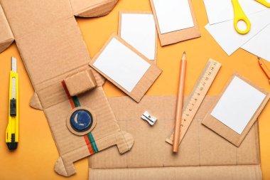 Turuncu arka planda karton fotoğraf makinesi yapmak için malzemeler