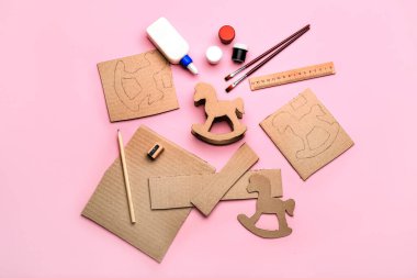 Karton sallanan atı pembe arka planda yapmak için malzemeler