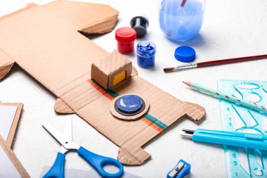 Beyaz arkaplanda karton fotoğraf makinesi yapmak için malzemeler