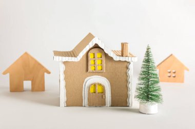 Işık arka planında köknar ağacı olan oyuncak evler