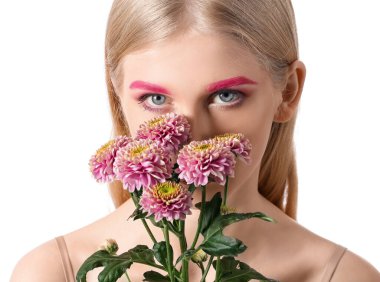 Yaratıcı makyajlı bir kadın beyaz arka planda bir buket çiçek tutuyor.