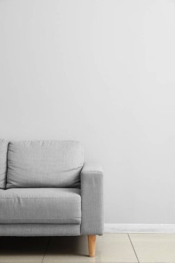 Işık duvarının yanındaki gri kanepe