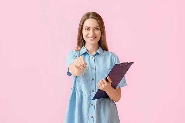 Lächelnde Junge Frau Mit Hausschlüsseln Und Klemmbrett Auf Rosa Hintergrund — Stockfoto