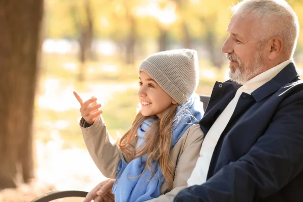 小女孩指着什么东西和她在公园的祖父 — 图库照片