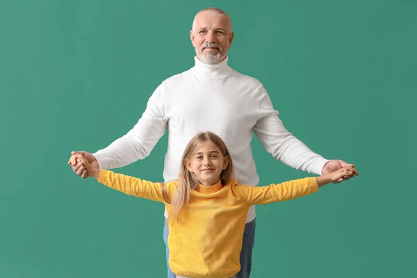 Klein Meisje Met Haar Grootvader Hand Hand Groene Achtergrond — Stockfoto