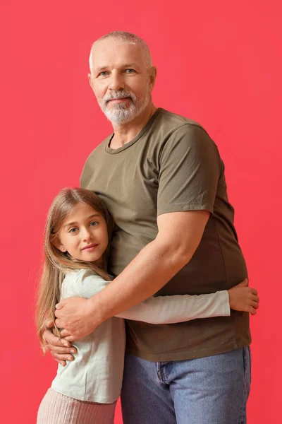 Little Girl Her Grandfather Hugging Red Background — Stock Photo, Image