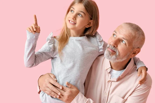 Niña Apuntando Algo Abuelo Sobre Fondo Rosa — Foto de Stock