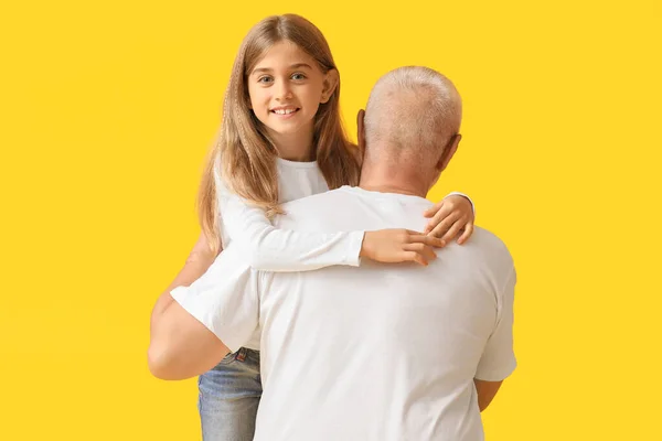 Niña Abrazando Abuelo Sobre Fondo Amarillo —  Fotos de Stock