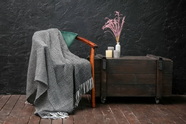 Koltuklu, ekoseli ve çekmeceli karanlık odanın içi.