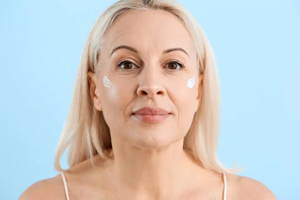 Ältere Blonde Frau Mit Gesichtscreme Auf Blauem Hintergrund Nahaufnahme — Stockfoto
