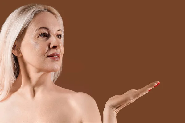 Mature Blonde Woman Showing Something Brown Background — Stock Photo, Image