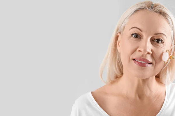Mature Blonde Woman Facial Massage Tool Light Background — Stock Photo, Image
