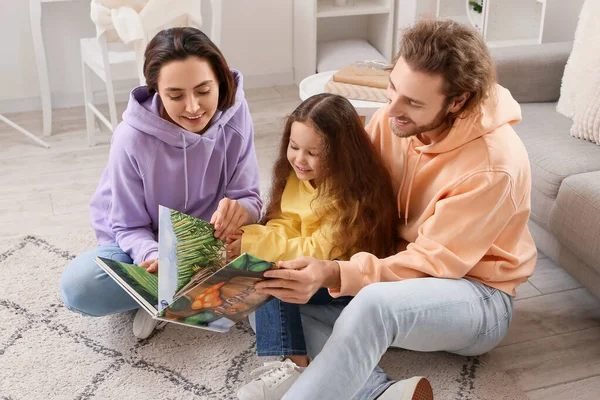Νεαρή Οικογένεια Διαβάζοντας Βιβλίο Μαζί Στο Σπίτι — Φωτογραφία Αρχείου