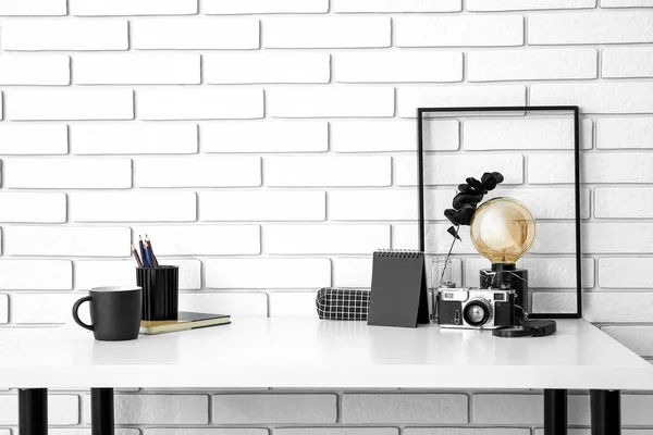 Workplace Lamp Photo Camera Cup Stationery White Brick Wall — Stock Photo, Image