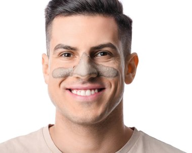 Beyaz arka planda uygulamalı kil maskeli yakışıklı adam, yakın plan.