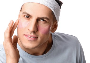 Beyaz arka planda göz altı yamaları olan yakışıklı bir adam, yakın plan.