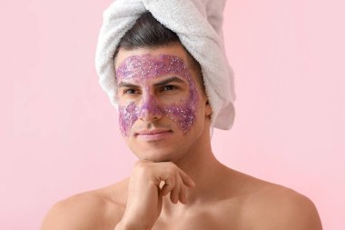 Pembe arka planda parlak maskeli ve havlusu olan yakışıklı adam, yakın plan.