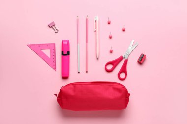 Pembe arka planda okul kırtasiyesi olan kalem kutusu, üst görünüm