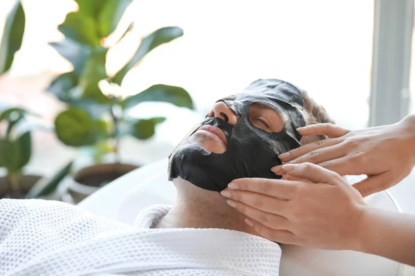 Cosmetologist Applying Sheet Mask Young Man Face Salon Closeup — Stock Photo, Image