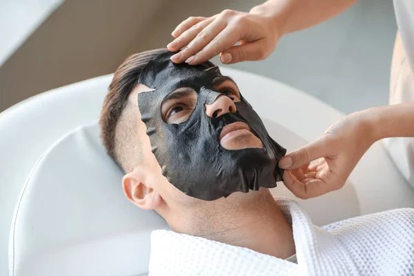 Cosmetologist Applying Sheet Mask Young Man Face Salon Closeup — Stock Photo, Image