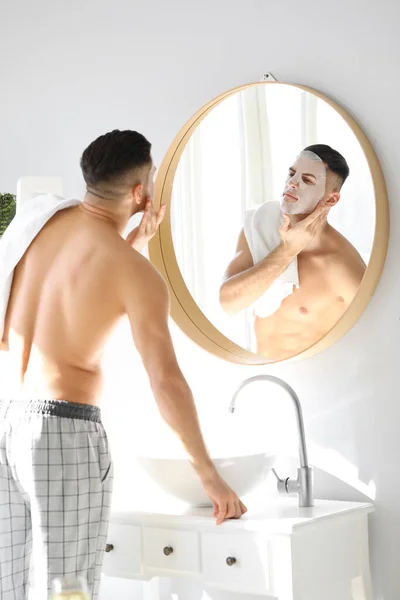 Snygg Man Med Ansiktsmask Nära Spegel Badrummet — Stockfoto