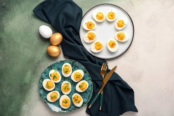 Doldurulmuş yumurta, çatal bıçak takımı ve arkaplanda peçete olan tabaklar. Paskalya kutlaması