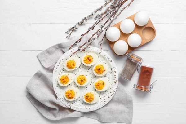 Πιάτο Γεμιστά Αυγά Μπαχαρικά Χαρτοπετσέτα Και Κλαδιά Ιτιάς Λευκό Ξύλινο — Φωτογραφία Αρχείου