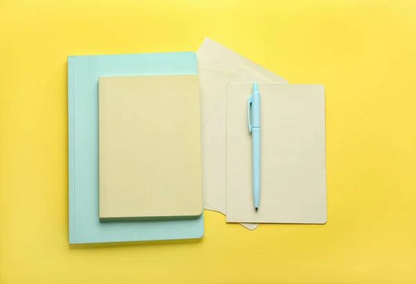 黄色背景上的笔记本和笔 顶视图 — 图库照片