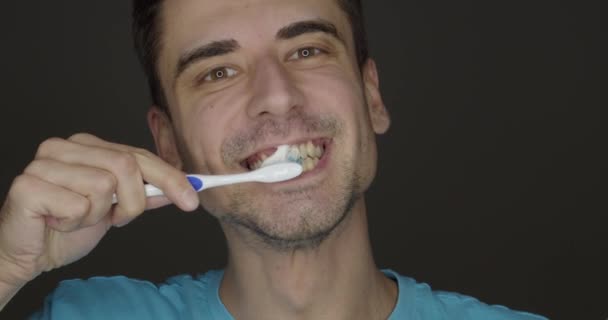 Happy Young Man Brushing Teeth Dark Background Video Clip