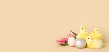 Tatlı tavuklar, laleler ve renkli arkaplanda paskalya yumurtaları.