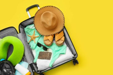 Kadın plaj aksesuarları ve sarı arka planda şnorkelli maske.