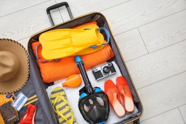 Kadın plaj aksesuarları, bağışıklık sertifikası ve beyaz ahşap arka planda şnorkelli maske.