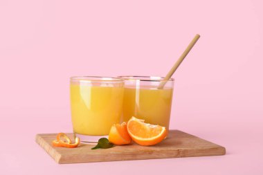 Pembe arka planda taze mandalina suyu.