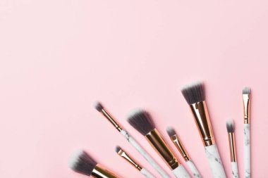 Pembe arka planda yeni makyaj fırçaları