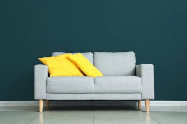 Renkli duvarın yanındaki yastıklı modern kanepe.