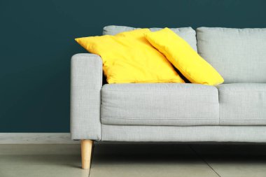 Renkli duvarın yanındaki yastıklı modern kanepe.