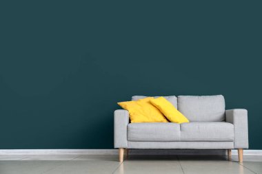 Renkli duvarın yanındaki yastıklı modern kanepe.